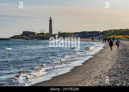 Touristen entlang der sandigen Grenener Halbinsel, wo die Ostsee auf die Nordsee trifft. Im Hintergrund der Skagen Leuchtturm. Skagen, Dänemark Stockfoto