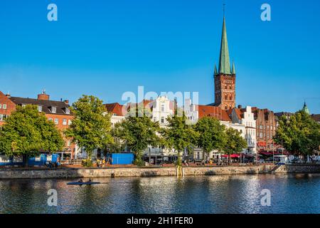 Typische Häuser der Stadt Lübeck mit Blick auf die Trace. Über den Dächern der Häuser erhebt sich der Glockenturm der Kirche San Pietro. Stockfoto