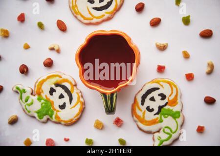 Halloween Kreativkonzept: Kürbisbecher und hausgemachte Kekse in Form von niedlichen Kürbissen und GeisterNahaufnahme. Ästhetische Herbststimmung oder Trick or Treat Konz Stockfoto