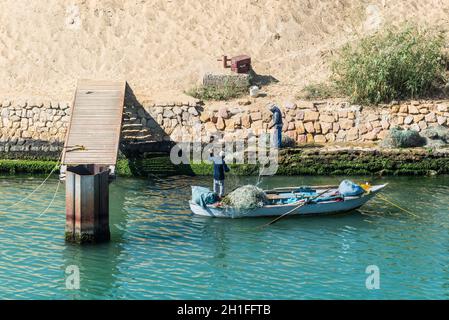 Ismailia, Ägypten - November 5, 2017: Fischer entwirren Netze auf den Suez Kanal in der Nähe von Ismailia, Ägypten, Afrika. Stockfoto