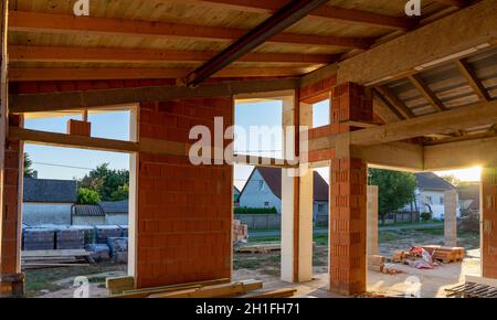 Haus unter Baubedingungen mit modernen Backsteinwänden und Löchern für Türen und Fenster Stockfoto