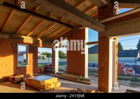 Haus unter Baubedingungen mit modernen Backsteinwänden und Löchern für Türen und Fenster Stockfoto