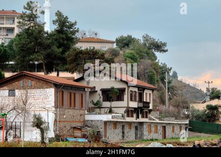Altes kleines Haus in der Nähe des Ufers von Kursunlu, Bursa. Haus aus Steinmaterial und roten Ziegeln mit riesigen Wolkenhimmel bei bewölktem Himmel Stockfoto
