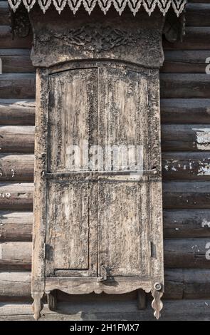 Geschlossene verwitterte Fensterläden eines traditionellen Holzhauses in Ulan-Ude. Republik Burjatien, Russland Stockfoto