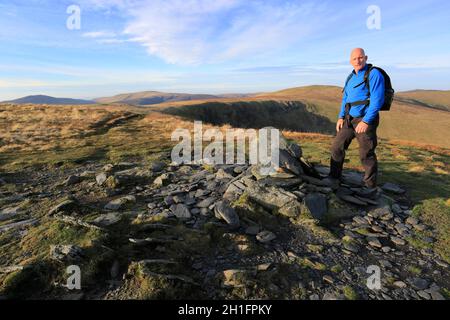 Walker auf dem Gipfelsturm von Bannerdale Crags Fell, Lake District National Park, Cumbria, England Stockfoto