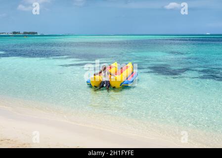 Nassau, Bahamas - 3. Mai 2019: Banana Boat auf dem Goodman's Beach in Nassau, Bahamas. Aufblasbare Bananen für Gruppen-Skaten auf dem Meer. Aktive Erholung, e Stockfoto