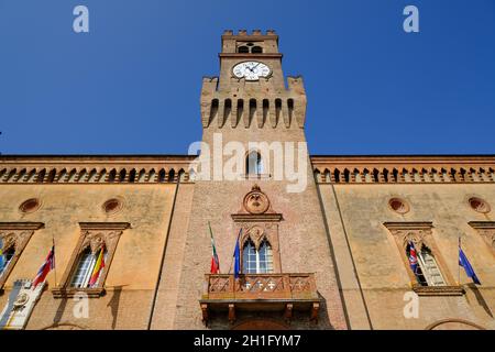 Neugotischer Turm mit Uhr aus roten Ziegeln. Rocca Pallavicino ist das Gebäude, in dem sich die Stadt Busseto und das Giuseppe Verdi Theater befinden Stockfoto