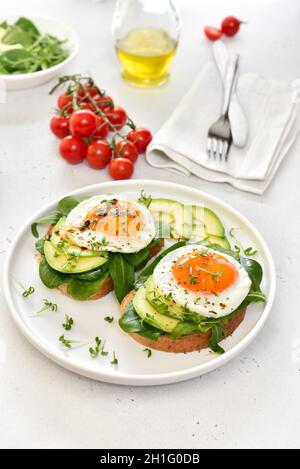 Spiegeleier, Avocado und Gemüse auf geröstetem Brot, Nahaufnahme Stockfoto