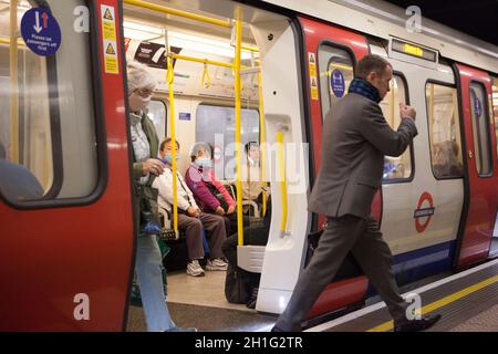 London, Großbritannien, 18 Uhr 2021: Menschen, die mit Gesichtsmasken in der Londoner U-Bahn unterwegs sind. Gesichtsbezüge sind in London für den öffentlichen Nahverkehr obligatorisch, werden aber nicht von allen an U-Bahn- und nicht an Bussen getragen. Obwohl einige Menschen eine medizinische Ausnahme haben, ist der Anteil der Menschen, die ohne sie gehen, viel höher, als medizinische Gründe erklären können. Anna Watson/Alamy Live News Stockfoto