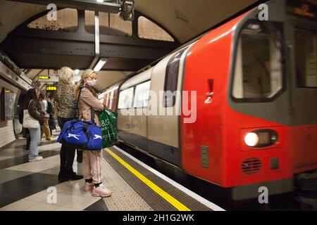 London, Großbritannien, 18 Uhr 2021: Menschen, die mit Gesichtsmasken in der Londoner U-Bahn unterwegs sind. Gesichtsbezüge sind in London für den öffentlichen Nahverkehr obligatorisch, werden aber nicht von allen an U-Bahn- und nicht an Bussen getragen. Obwohl einige Menschen eine medizinische Ausnahme haben, ist der Anteil der Menschen, die ohne sie gehen, viel höher, als medizinische Gründe erklären können. Anna Watson/Alamy Live News Stockfoto