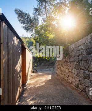 Hintergrundbeleuchtete Perspektive entlang der Holzfassade. Pavilion House, Guimarães, Portugal. Architekt: Diogo Aguiar Studio, 2019. Stockfoto