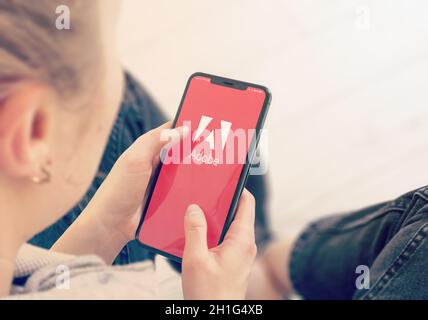 KIEW, UKRAINE-JANUAR, 2020: Adobe auf Handy-Bildschirm. Junges Mädchen zeigt oder schaut auf Adobe-Website während einer pandemischen Selbstisolation und Coronavir Stockfoto