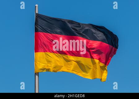 Deutsche Fahnen im Wind am berühmten Reichstag, Sitz des deutschen Parlaments (Deutscher Bundestag), an einem sonnigen Tag mit blauen Himmel, Centr Stockfoto