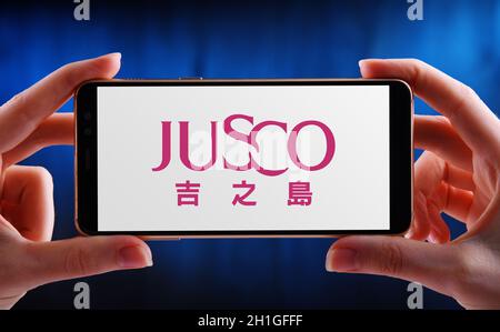 POSEN, POL - 21. MAI 2020: Hände halten Smartphone mit Logo von JUSCO, einer Kette von Hypermärkten in Japan Stockfoto