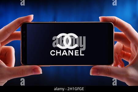 POZNAN, POL - JUN 12, 2020: Hand halten Smartphone mit Logo von Chanel, ein Luxus-Unternehmen, das sich auf High-Fashion und Ready-made Kleidung, l Stockfoto