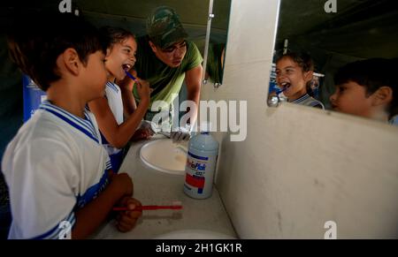 salvador, bahia / brasilien - 4. november 2015: Ein Militärangehöriger der brasilianischen Marine lehrt ein Kind, sich während der sozialen Aktion auf der Insel die Zähne zu putzen Stockfoto