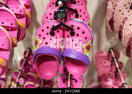 Tampa, USA - 2. August 2020: Rack mit vielen Paar weichen Gummisandalen oder Crocs in verschiedenen rosa, lila Farben in Tampa, USA am August Stockfoto