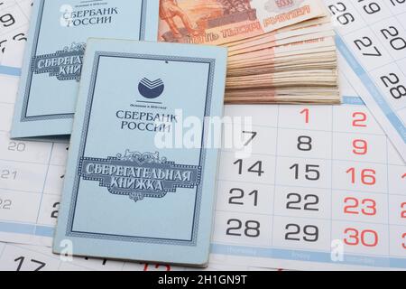Anapa, Russland - 29.06.2020: Im Hintergrund der Kalender ist ein Bündel von fünftausendsten Scheinen und Sparbüchern Stockfoto