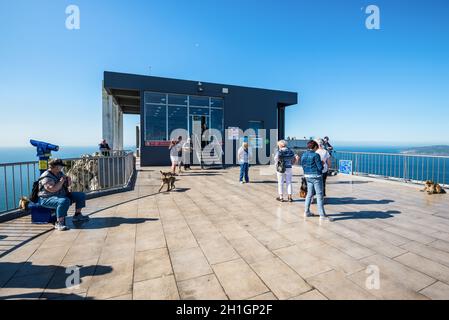 Gibraltar, UK - 18. Mai 2017: Touristen und Berberaffen auf der Aussichtsplattform auf der oberen Station der Seilbahn auf den Felsen von Gibraltar, Vereinigtes Königreich, W Stockfoto