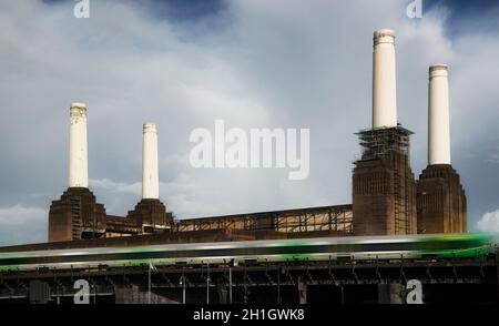 London, Vereinigtes Königreich - 01. Oktober 2006: Vier Schornsteine des stillgelegten Kohlekraftwerks Battersea mit grünem U-Bahn-Zug, der sich im Vorfeld schnell bewegt Stockfoto