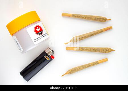 Calgary, Alberta, Kanada. August 19 2020. Ein weißer und gelber Kunststoff-Verpackungsbehälter aus Cannabis mit Zigaretten, Prerolls oder Fugen und einem Feuerzeug auf einem Stockfoto