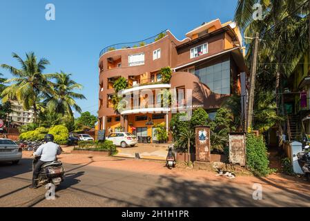 Candolim, North Goa, Indien - 23. November 2019: Straßenansicht von North Goa an sonnigen Tag mit geparkten Autos in der Nähe von Touristenläden und Hotel in Candolim, Nord Stockfoto