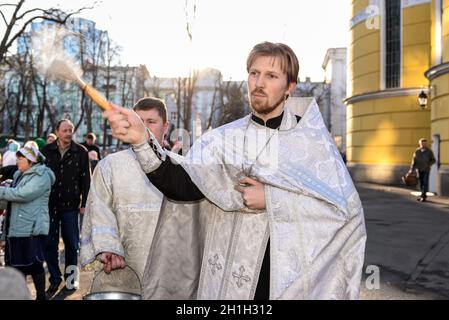 Kiew, Ukraine - April 8, 2018: Priester segnet die glückliche Menschen während der Heiligen Ostersonntag Zeremonie ausserhalb des hl. Wladimir Kathedrale in Kiew, Ukraine. Stockfoto