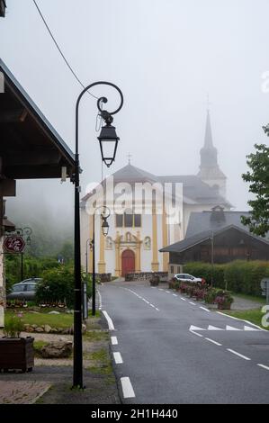 Blick auf die Bergkapelle in einem nebligen kleinen Dorf in der Nähe von Saint-Gervais-les-Bains, Savoyen, Frankreich im Sommer Stockfoto
