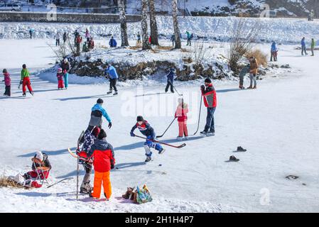 Liptovsky Hradok, Slowakei - März 03, 2018: Menschen aller Altersgruppen mit sonnigen Tag, Schlittschuhlaufen und Eishockey auf einem zugefrorenen See, wenn temper Stockfoto