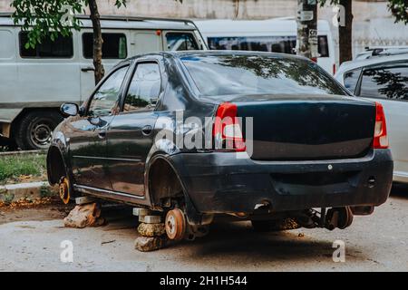 Zaporozhye, Ukraine - Juli 14 2020 : Ein zerbrochener Pkw ohne Räder steht auf Ziegelsteinen Stockfoto