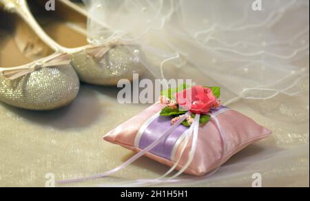 Weiße Schleierspitze, glänzendes silbernes Diadem und rosa Brautschuhe. brautzubehör Set für die Ehe Stockfoto