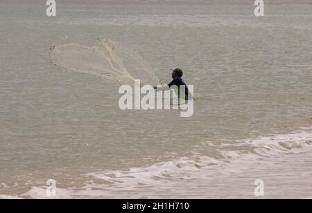 santa cruz cabralia, bahia / brasilien - 13. dezember 2010: Fischer werden gesehen, wie sie sein Netz am Strand von Coroa Vermelha in der Stadt Santa Cruz Cabrália werfen Stockfoto