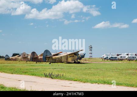 Alte zerstörte verlassene Flugzeuge und Hubschrauber auf dem Feld, Friedhof von alten Hubschraubern und Flugzeugen. Stockfoto