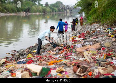 Muradnagar, Indien. Oktober 2021. Ein Mann sammelt wertvolle Gegenstände von den Stapeln am Ufer des Ganges-Kanals in Muradnagar. Im oberen Ganges-Kanal, der von schweren Bächen am Ufer des Kanals angehäuft wird, suchen die Einheimischen gerne nach wertvollen Gegenständen. Eifrige Anhänger bieten während eines Tauchgangs im Ganga-Kanal Wertsachen als religiöse Praxis an oder verlieren sie dort unwissentlich. Kredit: SOPA Images Limited/Alamy Live Nachrichten Stockfoto