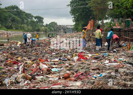 Muradnagar, Indien. Oktober 2021. Am Ufer des Ganges-Kanals in Muradnagar sammeln Einheimische wertvolle Gegenstände aus Müllhaufen.im oberen Ganges-Kanal, der von schweren Bächen am Ufer des Kanals aufgetürmt wird, suchen Einheimische gerne nach wertvollen Gegenständen. Eifrige Anhänger bieten während eines Tauchgangs im Ganga-Kanal Wertsachen als religiöse Praxis an oder verlieren sie dort unwissentlich. Kredit: SOPA Images Limited/Alamy Live Nachrichten Stockfoto