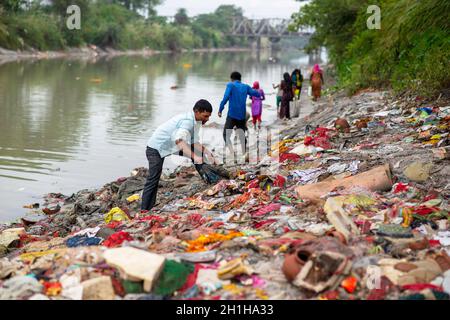 Muradnagar, Indien. Oktober 2021. Ein Mann sammelt wertvolle Gegenstände von den Stapeln am Ufer des Ganges-Kanals in Muradnagar. Im oberen Ganges-Kanal, der von schweren Bächen am Ufer des Kanals angehäuft wird, suchen die Einheimischen gerne nach wertvollen Gegenständen. Eifrige Anhänger bieten während eines Tauchgangs im Ganga-Kanal Wertsachen als religiöse Praxis an oder verlieren sie dort unwissentlich. (Foto von Pradeep Gaur/SOPA Images/Sipa USA) Quelle: SIPA USA/Alamy Live News Stockfoto