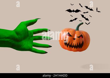 Zombie's grüne Hand mit Kürbis. Halloween Minimalkonzept. Stockfoto