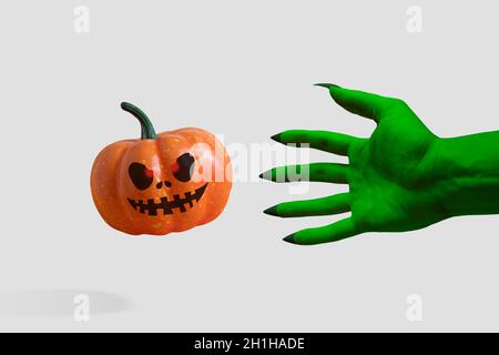 Zombie's grüne Hand mit Kürbis. Halloween Minimalkonzept. Stockfoto