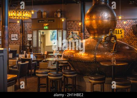 Bushmills, Nordirland, Aug 2019 großer, fermentierischer Kupferkessel in der Whiskey-Bar von Bushmills als Dekoration, Besucherzentrum der Destillerie und Laden Stockfoto