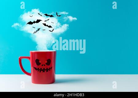 Halloween-Feier-Konzept mit einer Tasse Kaffee oder heißen Getränken und Fledermäusen auf weißem Tisch. Minimales Urlaubskonzept. Stockfoto