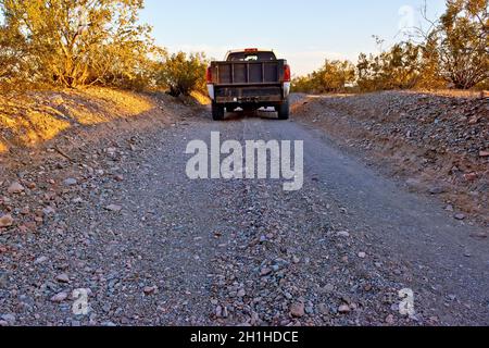 Eine sehr schmale Schotterstraße in einem abgelegenen Gebiet in der Nähe von Tonopah Arizona. Die Straße ist so schmal, dass jeweils nur ein Fahrzeug durchfahren kann. Stockfoto