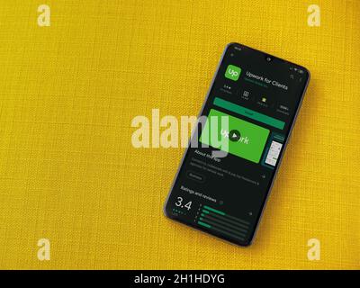 LOD, Israel - 8. Juli 2020: Upwork für Kunden App Play Store-Seite auf dem Display eines schwarzen Smartphone auf einem gelben Stoff Hintergrund. Draufsicht Stockfoto