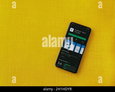 LOD, Israel - 8. Juli 2020: Freelancer App Play Store-Seite auf dem Display eines schwarzen mobilen Smartphones auf einem gelben Stoff Hintergrund. Draufsicht flach la Stockfoto