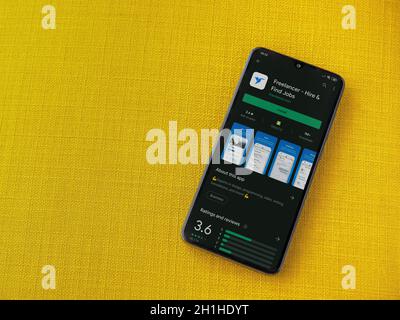 LOD, Israel - 8. Juli 2020: Freelancer App Play Store-Seite auf dem Display eines schwarzen mobilen Smartphones auf einem gelben Stoff Hintergrund. Draufsicht flach la Stockfoto
