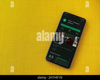 LOD, Israel - 8. Juli 2020: Fiverr App Play Store Seite auf dem Display eines schwarzen Smartphone auf einem gelben Stoff Hintergrund. Draufsicht Wohnung lag wi Stockfoto