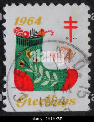 Die in den USA gedruckte Weihnachtsmarke zeigt einen Strumpf mit Geschenken, um 1964 Stockfoto