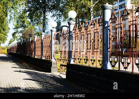 Metallzaun und Tor mit Laternen im Herbstpark Stockfoto