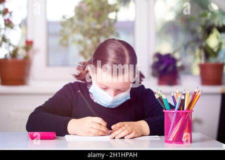 Schulkind trägt Maske zum Schutz vor Coronavirus in der Schule. Maßnahmen zur Verhinderung der Ausbreitung von COVID-19 an Schulen während des Coronavirus pande Stockfoto