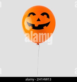 Orangefarbener Halloween-Ballon auf weißem Hintergrund isoliert. Minimales Halloween-Konzept. Stockfoto