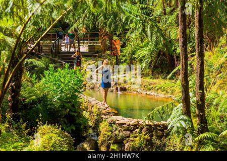 Sao Miguel, Azoren, Portugal, 16. August 2020: Touristen beobachten den Dampf von heißen Quellen und Fumarolen am Rande von Caldeira Velha Stockfoto